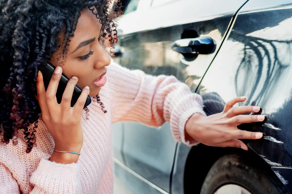 Vrouw aan het bellen bij een auto